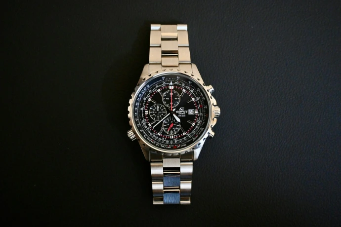 a watch sitting on top of a metal bracelet